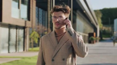 Gölün kıyısındaki bir şehirde cep telefonuyla konuşan çok çekici bir adam. Kendine güvenen genç iş adamları dışarıda konuşuyorlar.