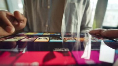 Afro-Amerikan erkek eller tabletten film izlemek için yayın platformunu kullanıyor. Gündelik giysiler içinde tanınmayan bir adam tavsiye listelerine bakarak film seçebilmek için internet sitelerine göz atıyor. Rahatla.