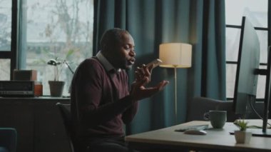Akıllı telefonu elinde tutan kızgın Afrikalı bir adamın görüntüsü. Meslektaşıyla duygusal konuşmalar, el kol hareketi. Sinirli patron ve çalışanın sohbeti. İçeride. Uzaktan kumanda. Hafta sonu. İletişim