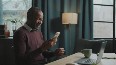 Mutlu, yakışıklı, gevşemiş, kahve içen ve öğle arasında akıllı telefondan mesaj atan Afrikalı bir adam. Keyifli bir iş adamı. Çatı katında ailesiyle sohbet ediyor. Gündüz