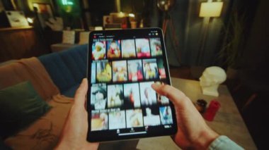 Eller evin oturma odasındaki kanepede uzanmış yatıyor. Tablet bilgisayarı kaydırılıyor. Çevrimiçi filmler ya da TV dizileri aranıyor