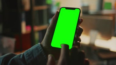 Mans elleri krom anahtar ekranlı akıllı telefonu tutuyor. Yeşil ekranlı cep telefonu görüntüsü. Cihaz. Modern aletler kullanan tanınmayan bir adam. Arka plan bulanık. Kapalı