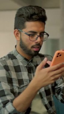 Gözlüklü komik sakallı adam evdeki kanepede oturan tablet bilgisayar kullanıyor. Gülümsemeyi düşünmek mutlu hissettiriyor. İletişim. Kamera hareket ediyor. 360 derece