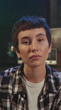 Ciddi şekilde odaklanmış, kendine güvenen, şık saç kesimli genç bir kadının portresi koltukta oturuyor ve akşamları rahat ofisin bulanık arka planında kameraya bakıyor. Yaratıcı kişi. Kapalı