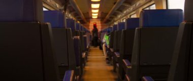 Tren vagonunda, sakin bir sahne sergilenir, boş koltuklar sergilenir, hafif, hafif ışıklandırmayla aydınlatılır.