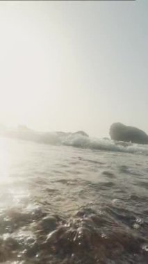 Sakin ve sakin bir sahne yumuşak ışıklandırma altında hafif okyanus dalgaları sergiliyor, rahatlama temaları için mükemmel.