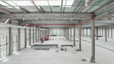 Çağdaş lojistik merkezinin yatay drone çekimi. Boş sanayi bölgesinin havadan görünüşü. Kamera depoda hareket ediyor. Malzeme deposu. Ticaret anlayışı. Yönetim süreci