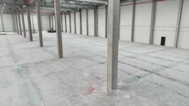 Modern deponun insansız hava aracı görüntüleri. Beton zemini olan boş sanayi bölgesi. Malları olmayan bir depo. Geniş, boş, aydınlık bir salon. Lojistik konsept. İş için. Dağıtım Merkezi