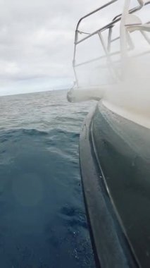 Okyanus dalgalarını kesen bir teknenin canlandırıcı enerjisini parlak bir şekilde yakalayan canlı ve büyüleyici bir görüntü.