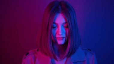 Güzel bir kadının büyüleyici portresi. Canlı pembe ve mavi renkli modern neon ışıkla aydınlatılmış.