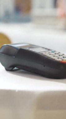 Modern işlem teknolojisi sunan, bir masanın üzerindeki, şık, temassız ödeme terminalinin yakın plan çekimi..