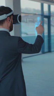 Bir işadamı, modern ofis ortamında holografik verilerle uğraşmak için sanal gerçeklik teknolojisini kullanıyor.