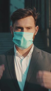 Modern bir şirket ortamında sağlık güvenliğinin önemini gösteren yüz maskesi takan bir iş adamı.