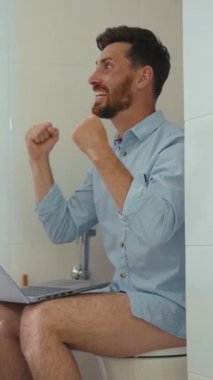 Bu komik videoda, bir adam dizüstü bilgisayarla tuvalette birden fazla iş yapıyor, günlük hayatın ve evden çalışmanın zorluklarını vurguluyor.