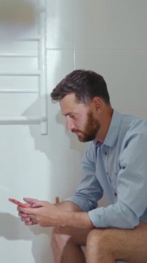 Bu komik kısa videoda, bir adam tuvalette otururken kendisini komik bir şekilde cep telefonuyla dikkati dağılmış bulur.