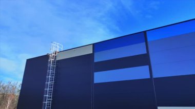 Maviyle boyanmış büyük modern lojistik deposunun yatay drone görüntüleri. Güneşli bir günde merkezin dış görüntüsü. Modern endüstriyel alan manzarası. Dağıtım merkezi. Açık havada.