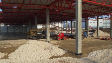 Gevşek çakıl ve çeşitli makinelerin özenle çalıştığı etkin bir inşaat alanının büyüleyici görüntüsü