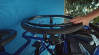 Tekerlekli sandalye süren genç bir basketbolcunun dış sahada top oynarken portresi. Spor sahası. Engelli. Yarışma.
