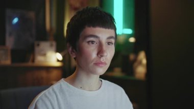 Bilgisayarın başında oturan ve ekrana bakan odaklanmış genç bir kadın. Modern çatı katının bulanık arka planındaki kameraya bakan şık kısa saçlı güzel bir kızın portresi. Kapalı