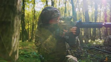 Ön planda keskin nişancı tüfeği olan silahlı bir dövüşçünün yatay görüntüleri. Ormanda operasyon yapan üniformalı askerler. Antrenman. Savaş ve savunma kavramı. Açık havada. Gündüz