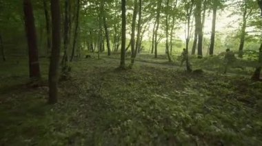 Düşman aramak için yeşil ormanda koşan silahlı iki askerin robot görüntüleri. Silahlı askerler.