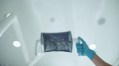 Tıbbi eldivenli, dişçi koltuğundaki ışığı ayarlayan dişçi eldivenli eller dişçi odasındaki hastaya lamba tutuyordu. Dişçi kliniği ekipmanları. İçeride. Tıp, sağlık hizmeti kavramı