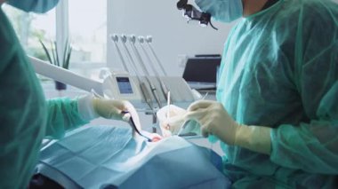 Diş hekimi ve asistanının ameliyat görüntüsü. Diş tedavisi. Doktor modern aletleri elinde tutuyor. Dişler. Tıbbi, sağlık hizmeti konsepti. İçeride. Klinik
