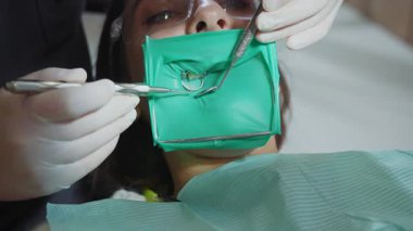 Diş dolgusu üzerinde çalışan el dişçisinin görüntülerini kapat. Sağlığa. Sabırlı ol. İşlem