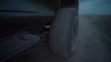 Akşamları yolda giden büyük araba tekerlekleri. Arkadaki toz. Yol. Ulaşım