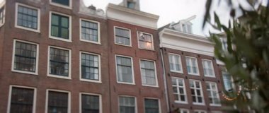 Benzersiz mimari özelliklerini güzel bir şekilde sergileyen geleneksel Amsterdam binalarının nefes kesici manzarası.
