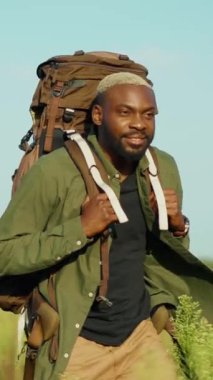 Bir adam sırt çantasıyla yürüyüş yapıyor, çarpıcı, berrak mavi gökyüzünün altındaki açık havanın tadını çıkarıyor.