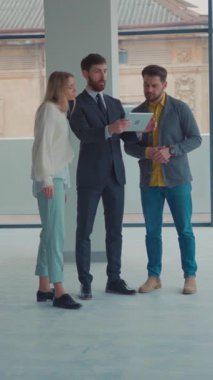 Üç yetenekli profesyonel parlak, modern ofis alanındaki fikirler hakkında düşünceli bir tartışmaya giriştiler.