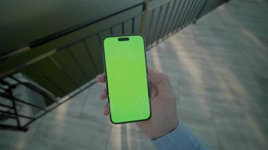 Yeşil ekran hareket ederken el ele tutuşup, dikey olarak telefonu kaydırmak. Arka plandaki gölde. Akıllı telefondan yazıyorum.