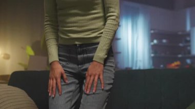 İçerideki kanepede oturan zarif, çekici, gülümseyen, beyaz bir kadının fotoğrafı. İşten sonra oturma odasında dinlenen güzel bir kız. Sıcak bir atmosfer. Akşam vakti. Çekim etrafında hareket eden izleme