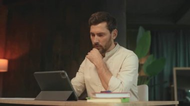 Masada oturan çekici sakallı adam tablet bilgisayar kullanıyor. Düşünüyorum. Kamera hareket ediyor. 360 Derece