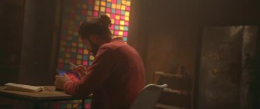 Düşünceli Kafkasyalı genç adam dijital tablete dokunuyor ve uzaklaşıyor. Yetenekli adam resmin detaylarını çiziyor. Grafik tasarım konsepti. Parallaks etkisi. 360 derecelik izleme atışı