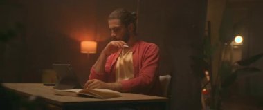 Evde çalışan Kafkas erkek grafik tasarımcısının görüntülerini takip eden enerjik hareketler. Yaratıcı sanatçı dijital tablet ekranında stilus ile ayrıntıları çiziyor. İşlem. Yaratıcılık konsepti. Parallaks