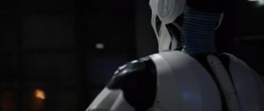 Akşamları karanlık oturma odasındaki masada oturan robotun yakın plan çekimleri. Android hareket eden eller ve işaret eden parmaklar. Yapay zeka. Gelecekçi insansı işçi. Kapalı