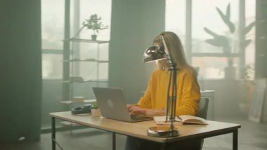 Ofiste dizüstü bilgisayarda yazan genç bir kadının etrafında hareket eden bir kamera. Yoğun bir iş günü. Düşünüyorum. 360 derece
