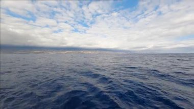 Estetik yaz deniz manzarası. Muhteşem derin mavi okyanus suyu, hareket eden dalgalar ve bulutlu gökyüzü. Deniz doğası kavramı.