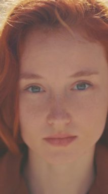 Bu samimi video, kızıl saçlı ve mavi gözlü bir kadının güzelliğini ve hassasiyetini gösteren yakın çekimler yoluyla duygularını gösteriyor.