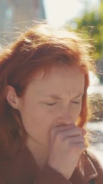 Videoda farklı duygular gösteren kızıl saçlı bir kadın var. Düşünme, öksürük ve yakın çekim ile başlıyor.