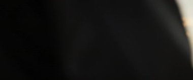 Arabanın yanında duran ve bagaja bakan yakışıklı, şık, kızıl saçlı bir adamın yatay görüntüsü. Odaklanmış ciddi bir adamın vurulması. Güneş ışığı. Dışarıda.