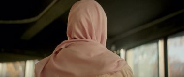 Türbanlı tatlı müslüman kadın, evde güneş ışığında sosyal medyada telefon kullanıyor. Mutlu ol. Kamera hareket ediyor. 360 derece