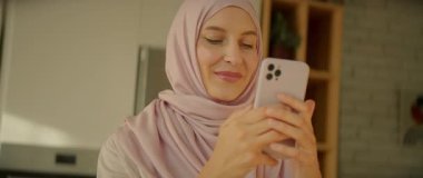 Türbanlı yüz müslümanı kadın, gün ışığında sosyal medyada telefon kullanıyor. Mutlu ol. Kamera hareket ediyor. 360 derece