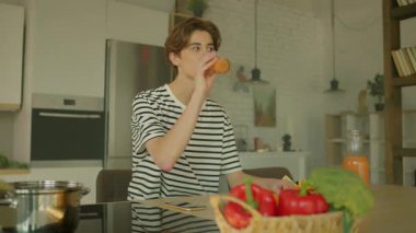 360 derece mutfak. Genç yakışıklı beyaz adam kahvaltı masasında oturup portakal suyu içerken modern rahat stüdyodaki akıllı telefon ekranına bakıyor. İz sürme