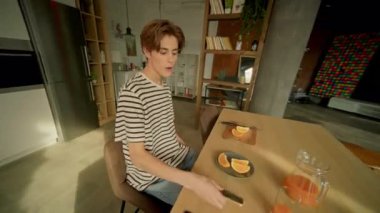 Erkek öğrencinin akıllı telefondaki uyarıları kontrol edişini görüntülüyordum. Kafkasyalı genç adam ekrandaki alete dokunuyor. Kaygısız adam video aracılığıyla konuşuyor. İnternet iletişimi. Parallaks