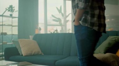 Çekici, gözlüklü genç bir adam kanepeye oturuyor ve eve tablet bilgisayar götürüyor. Düşünüyorum. İletişim. Kamera hareket ediyor. 360 derece