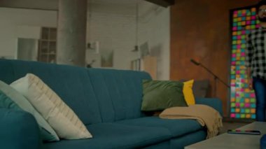 Kanepeye uzanmış gözlüklü yakışıklı adam gülümseyen akıllı telefon kullan mutlu ol. Sosyal medyada sohbet etmek. - Evde. Kamera hareket ediyor. 360 derece