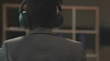 360 derecelik hızlandırılmış ofis. Üretken Afrikalı Amerikalı gülümseyen radyo sunucusu mikrofonda oturuyor ve akşam radyo dinleyicileriyle konuşuyor. Takım elbiseli genç talan kadın. Radyo istasyonu. İçerde çalış